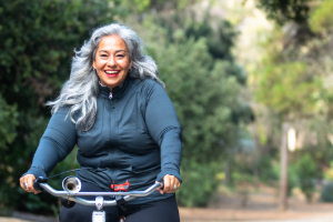 Senior Woman Riding bicycle after successful weight loss using hypnosis and hypnotism.