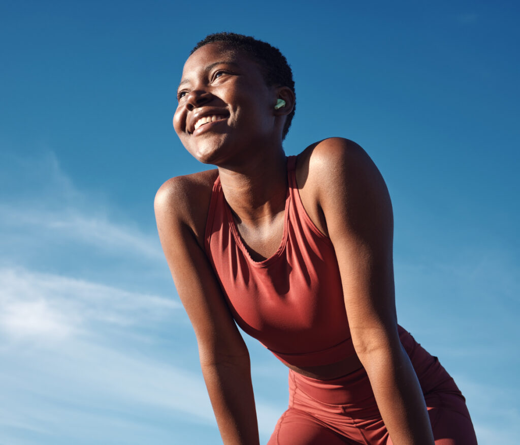 This happy black woman doesn't need weight loss injections. She enjoys exercising to achieve weight loss through hypnotherapy. After hypnosis and hypnotism she easily completes her outdoor workout.